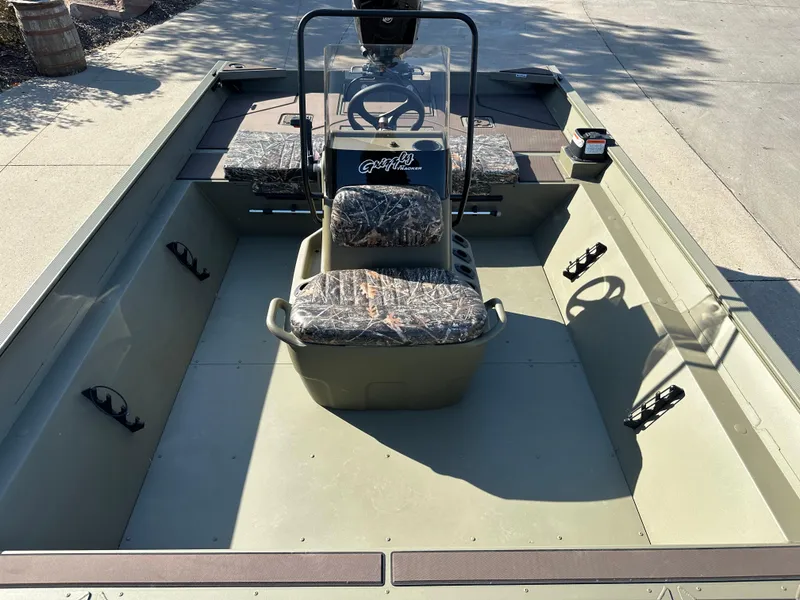 Slide: The Image of 2025 Tracker Grizzly 2072 CC boat interior with camo seats and steering console. - 5