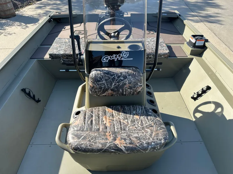 Slide: The Image of 2025 Tracker Grizzly 2072 CC boat interior with camo seats and steering console. - 6