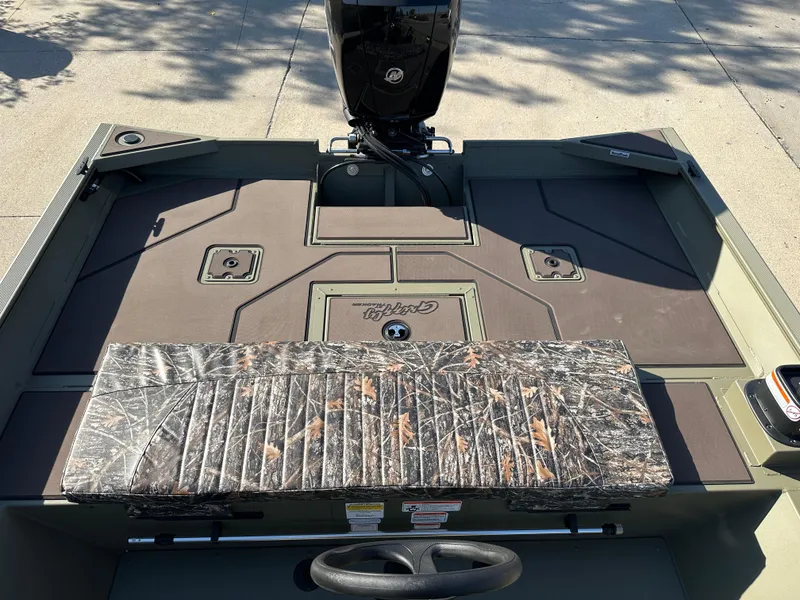 Slide: The Image of 2025 Tracker Grizzly 2072 CC boat interior with camouflage seating and steering wheel. - 7