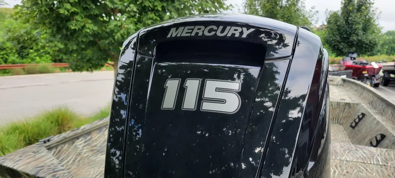 Slide: The Image of 2025 Tracker Grizzly 2072 CC with Mercury 115 outboard motor, parked outdoors. - 4