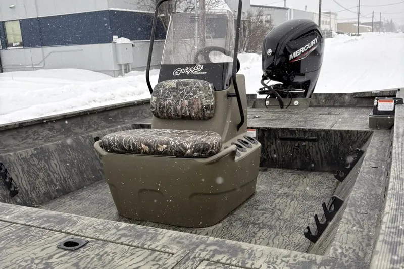 Slide: The Image of 2025 Tracker Grizzly 2072 CC boat with camo seating and Mercury outboard motor in snowy setting. - 6