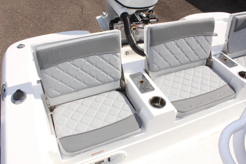 Slide: The Image of 2025 NauticStar 224 Bay boat with gray cushioned seating and cup holders. - 13
