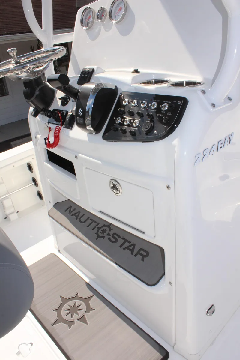 Slide: The Image of 2025 NauticStar 224 Bay boat console with steering wheel and control panel. - 18