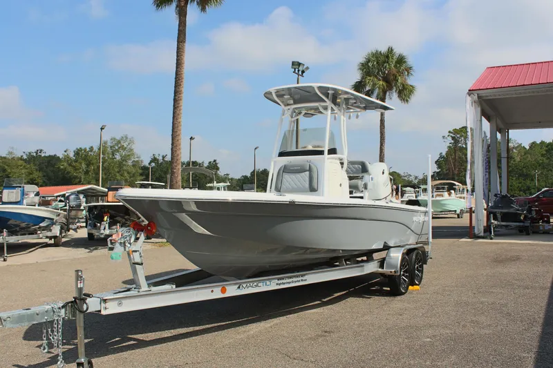 Slide: The Image of 2025 NauticStar 224 Bay boat on trailer, parked outdoors under clear sky. - 2
