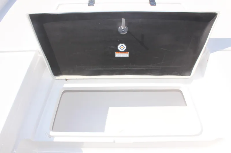 Slide: The Image of 2025 NauticStar 224 Bay storage compartment open, showcasing interior space. - 25