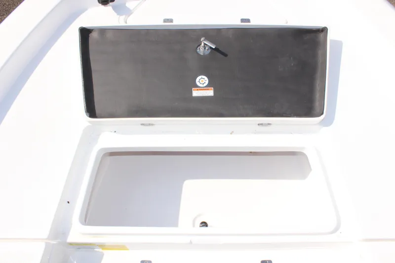 Slide: The Image of 2025 NauticStar 224 Bay boat storage compartment with open lid. - 26
