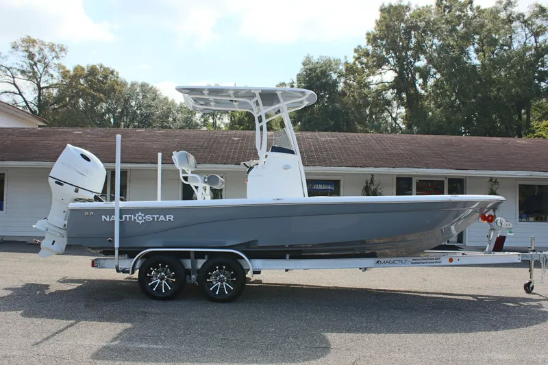 Slide: The Image of 2025 NauticStar 224 Bay boat on trailer, parked outdoors. - 4