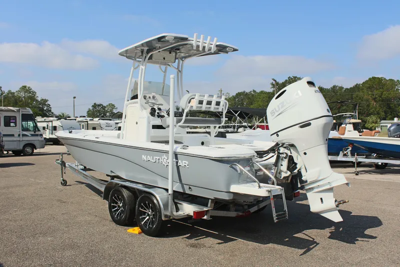 Slide: The Image of 2025 NauticStar 224 Bay boat on trailer, parked outdoors. - 7