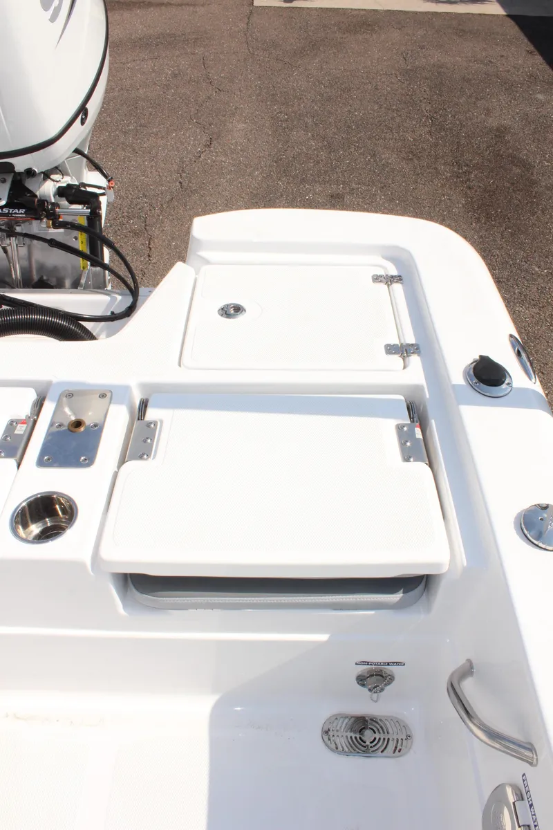 Slide: The Image of 2025 NauticStar 224 Bay boat deck with storage compartments and motor. - 9