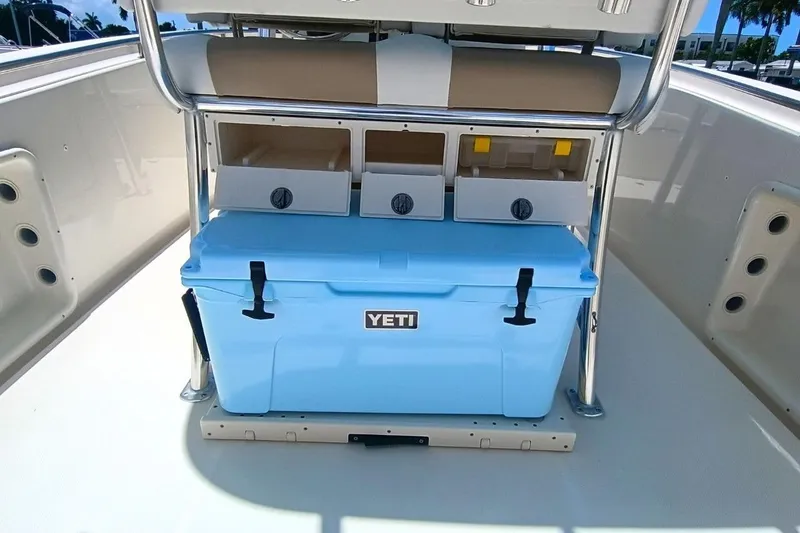 Slide: The Image of 2025 Bulls Bay 230 Center Console boat with blue Yeti cooler and storage compartments. - 10