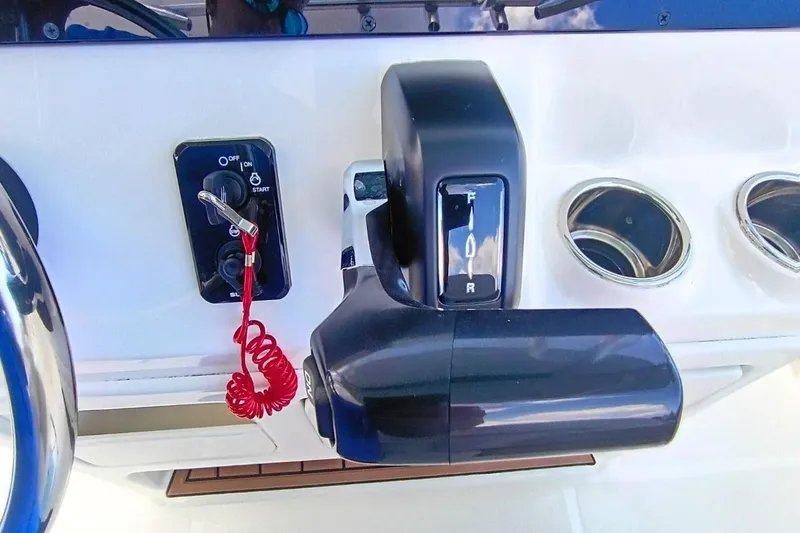 Slide: The Image of 2025 Bulls Bay 230 Center Console boat controls with ignition switch and throttle lever. - 21
