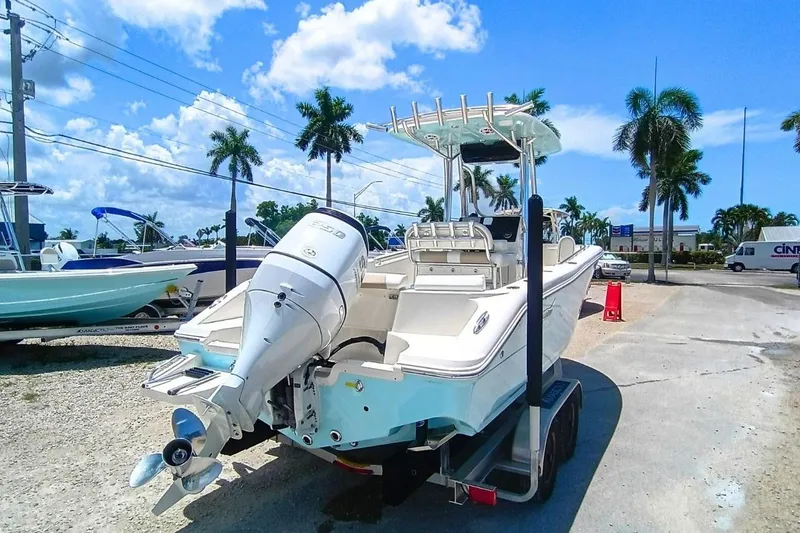 Slide: The Image of 2025 Bulls Bay 230 Center Console boat on trailer, sunny day, palm trees in background. - 4