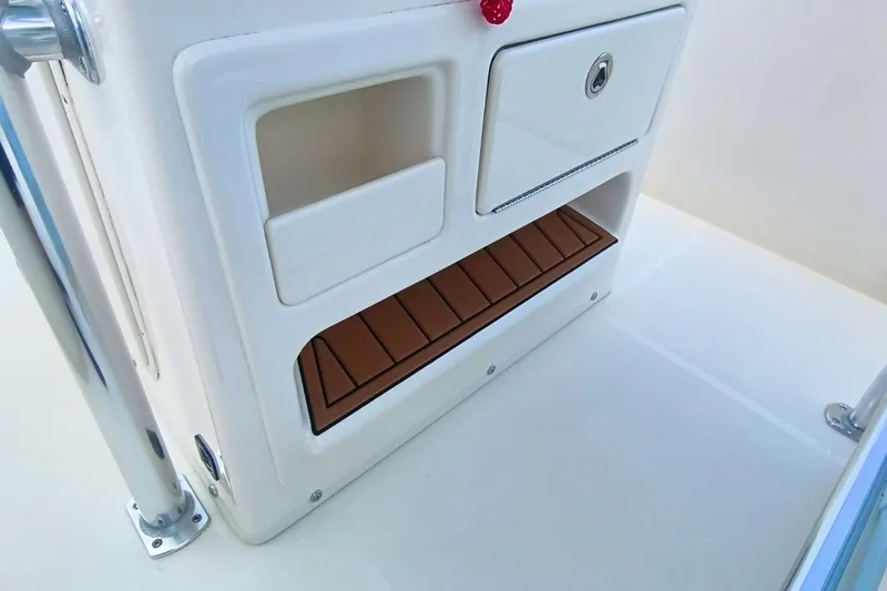 Slide: The Image of 2025 Bulls Bay 230 Center Console storage compartment with teak flooring and secure latch. - 25