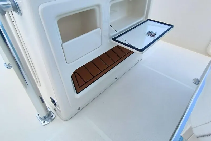 Slide: The Image of 2025 Bulls Bay 230 Center Console interior storage compartment with open hatch and teak flooring. - 26