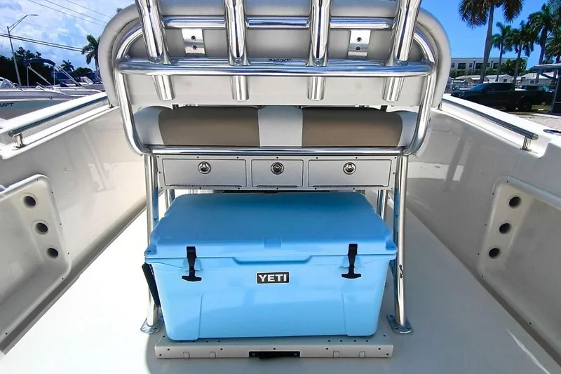 Slide: The Image of 2025 Bulls Bay 230 Center Console boat interior with blue Yeti cooler and storage drawers. - 9