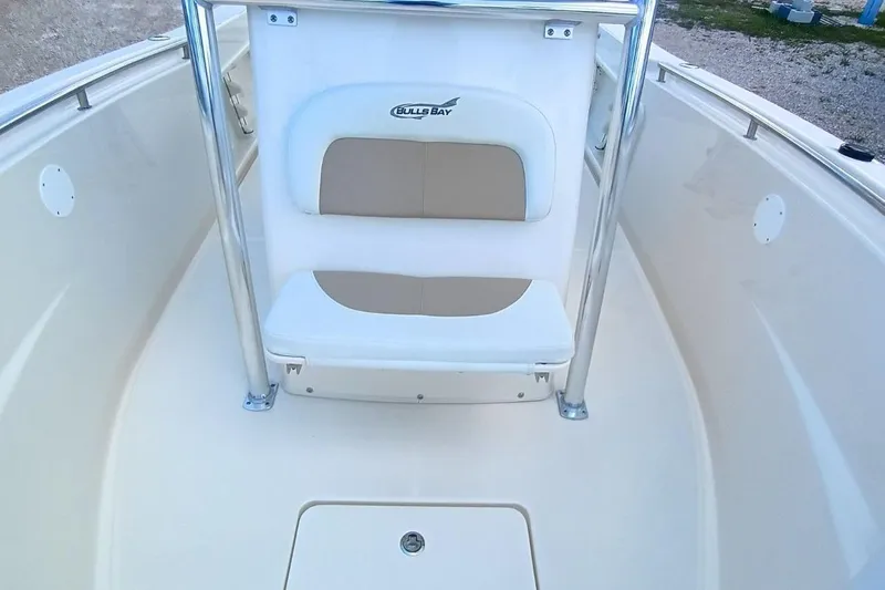 Slide: The Image of 2025 Bulls Bay 230 Center Console boat interior with cushioned seating and stainless steel rails. - 38