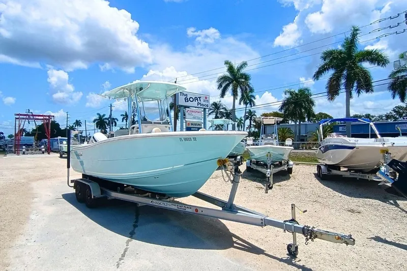 Slide: The Image of 2025 Bulls Bay 230 Center Console boat on trailer at dealership, sunny day, palm trees. - 2