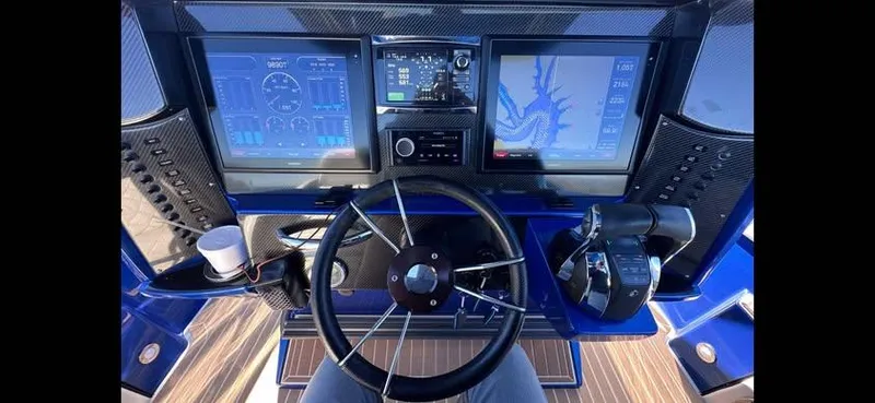 Slide: The Image of 2015 Nor-Tech 340 Sport Center Console dashboard with navigation screens and steering wheel. - 10