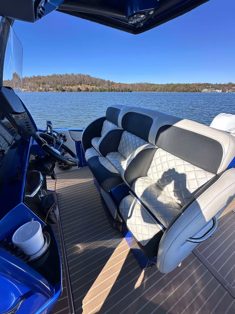 Slide: The Image of 2015 Nor-Tech 340 Sport Center Console boat interior with luxurious seating on a sunny day. - 13