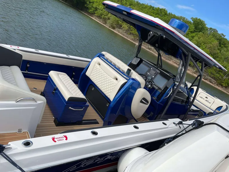 Slide: The Image of 2015 Nor-Tech 340 Sport Center Console boat on a lake, featuring blue and white interior. - 16