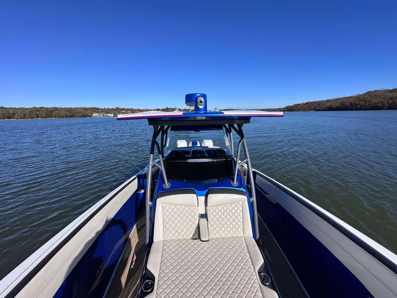 Slide: The Image of 2015 Nor-Tech 340 Sport Center Console on calm water, showcasing sleek design and spacious seating. - 18