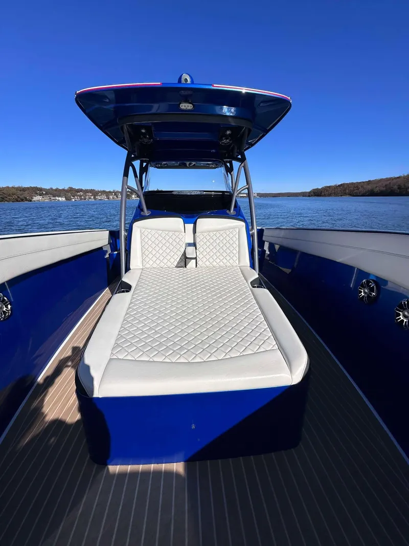 Slide: The Image of 2015 Nor-Tech 340 Sport Center Console boat with blue exterior on a calm lake. - 19