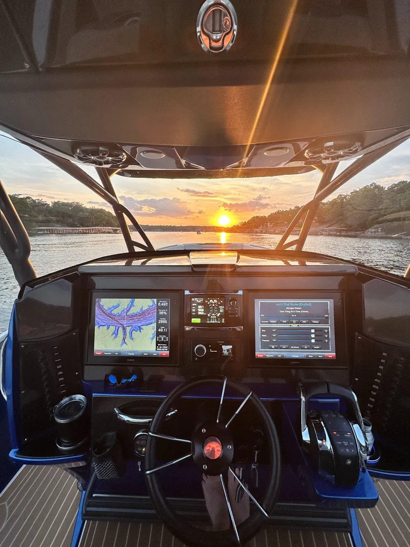 Slide: The Image of 2015 Nor-Tech 340 Sport Center Console dashboard at sunset on the water. - 2