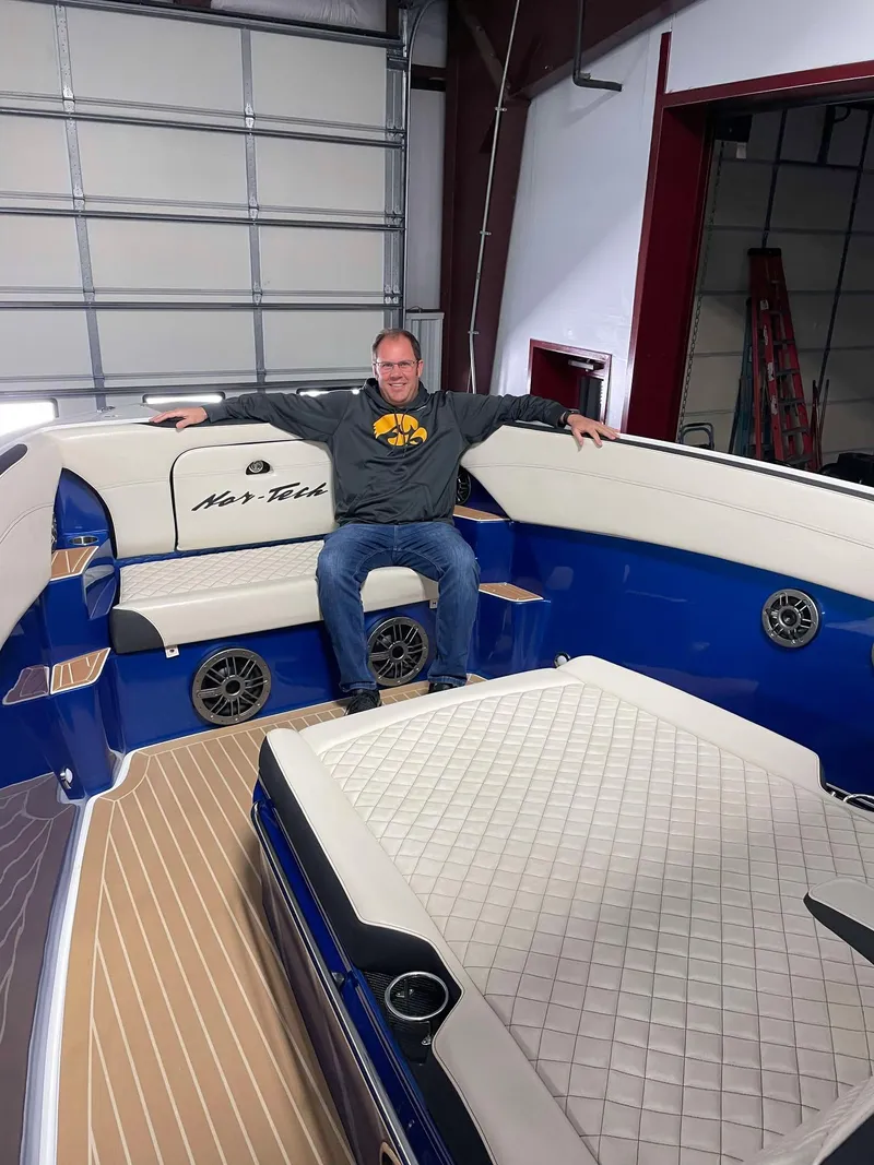 Slide: The Image of Man sitting on 2015 Nor-Tech 340 Sport Center Console boat in a garage. - 20