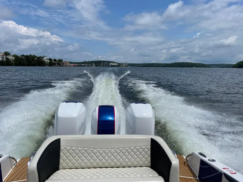 Slide: The Image of 2015 Nor-Tech 340 Sport Center Console cruising on a lake with powerful twin engines. - 21
