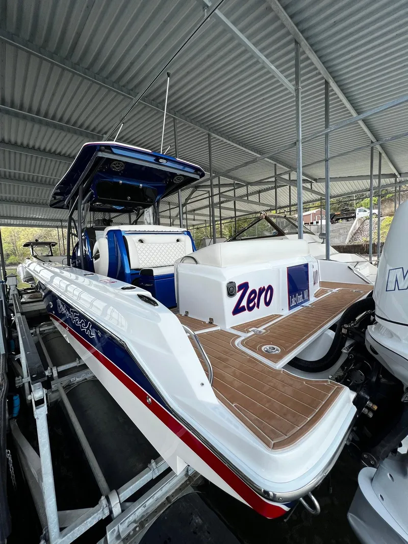 Slide: The Image of 2015 Nor-Tech 340 Sport Center Console boat docked under a metal canopy. - 22