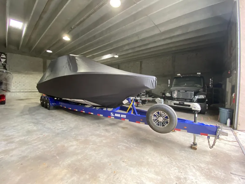 Slide: The Image of 2015 Nor-Tech 340 Sport Center Console boat covered on a trailer in a garage. - 29