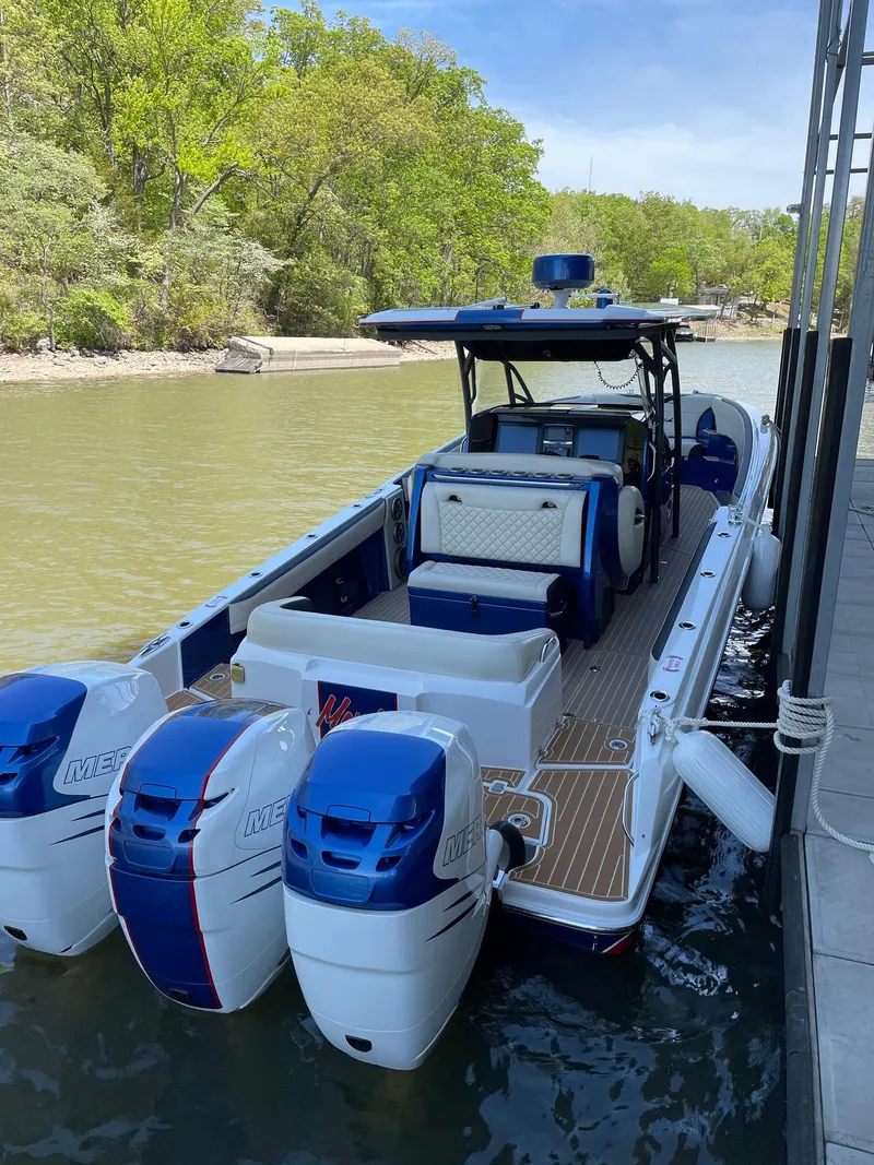 Slide: The Image of 2015 Nor-Tech 340 Sport Center Console boat docked, featuring triple outboard engines. - 5
