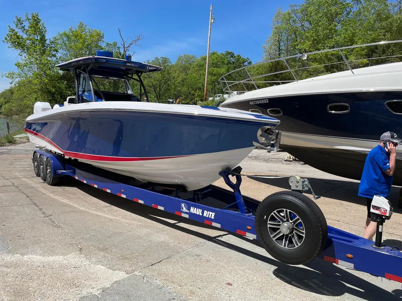 Slide: The Image of 2015 Nor-Tech 340 Sport Center Console boat on trailer, blue and white design. - 6