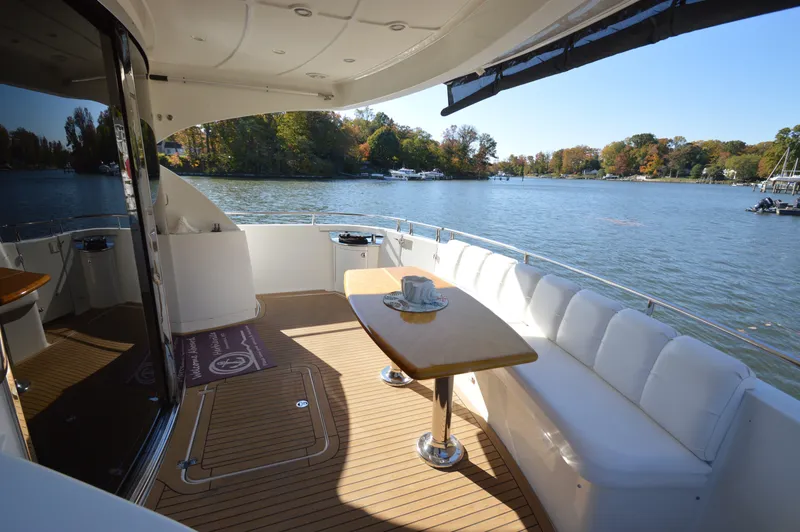 Slide: The Image of Luxurious 2007 Marquis 59 yacht deck with seating, table, and scenic water view. - 10