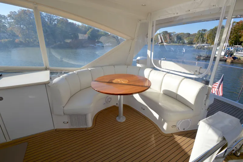 Slide: The Image of Luxurious 2007 Marquis 59 yacht interior with white seating and wooden table. - 14