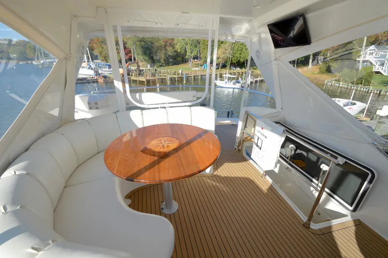 Slide: The Image of Luxurious 2007 Marquis 59 yacht interior with curved seating and wooden table. - 16