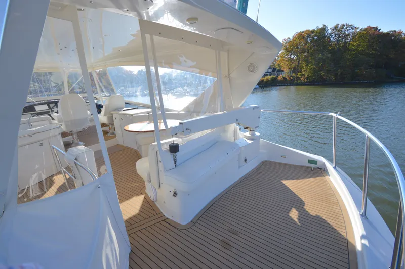 Slide: The Image of Luxurious 2007 Marquis 59 yacht deck with seating, overlooking serene water and lush trees. - 20