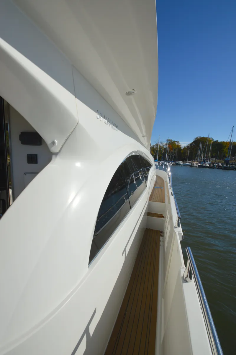 Slide: The Image of Side view of 2007 Marquis 59 yacht docked by a marina. - 25