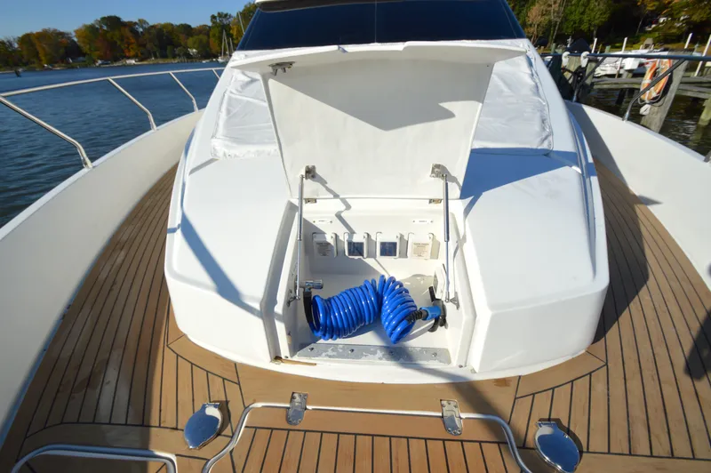 Slide: The Image of 2007 Marquis 59 yacht deck with open storage compartment and blue hose. - 28