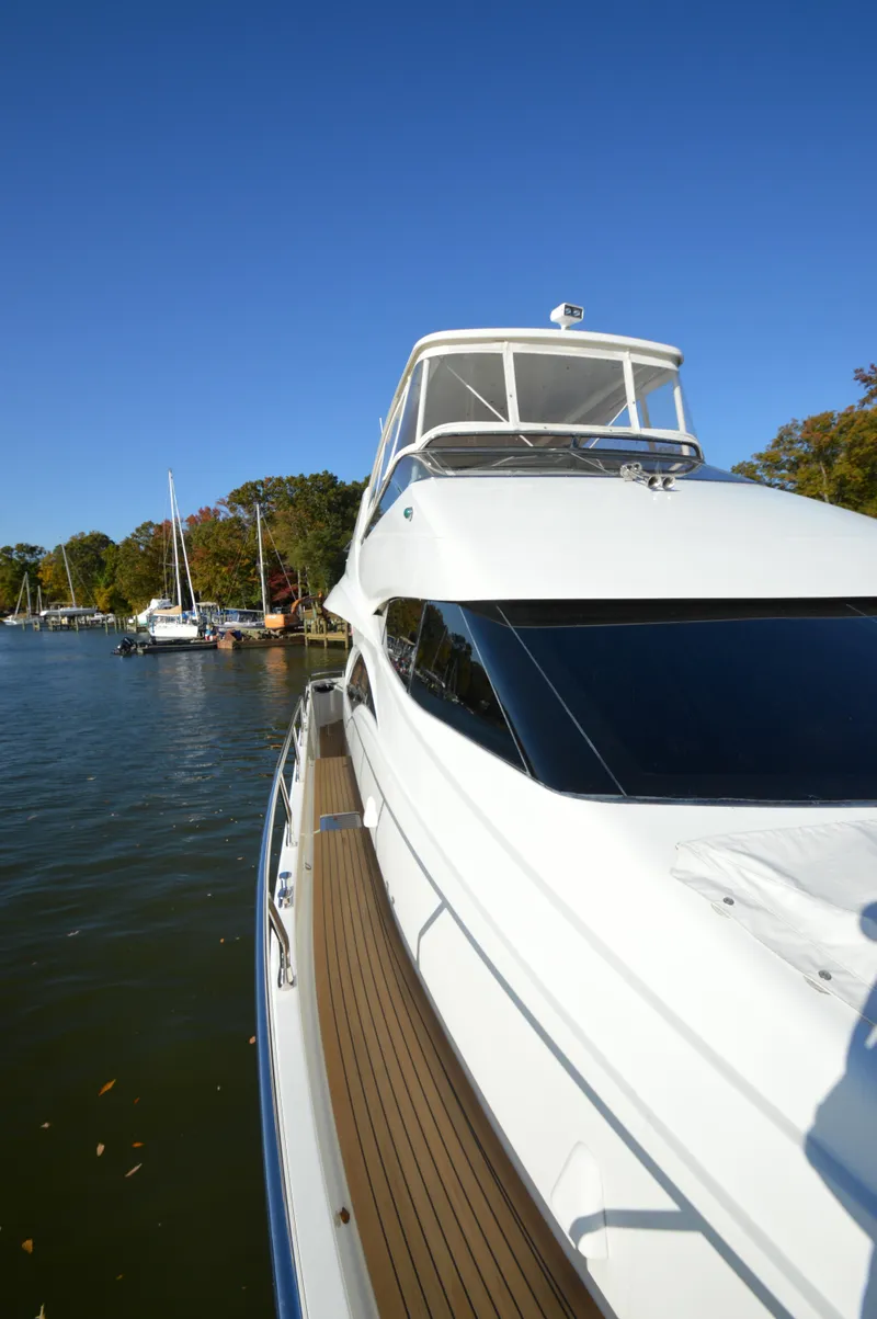 Slide: The Image of 2007 Marquis 59 yacht docked on a sunny day, surrounded by trees and water. - 29