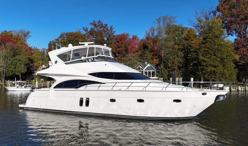Slide: The Image of 2007 Marquis 59 yacht cruising on a serene lake with autumn foliage. - 4