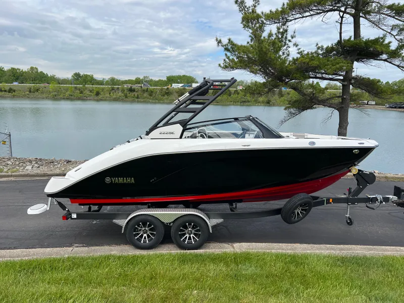 Slide: The Image of 2025 Yamaha Boats 222SE on trailer by a lakeside, showcasing sleek design and modern features. - 3