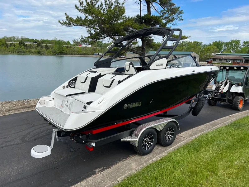 Slide: The Image of 2025 Yamaha Boats 222SE on trailer by a lakeside road. - 4