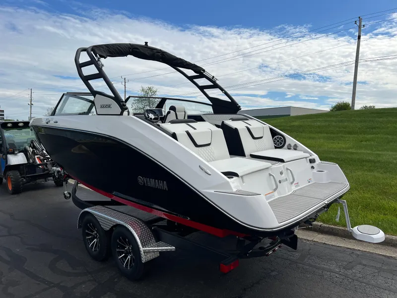 Slide: The Image of 2025 Yamaha Boats 222SE on trailer, sleek design, black and white color scheme, outdoor setting. - 6