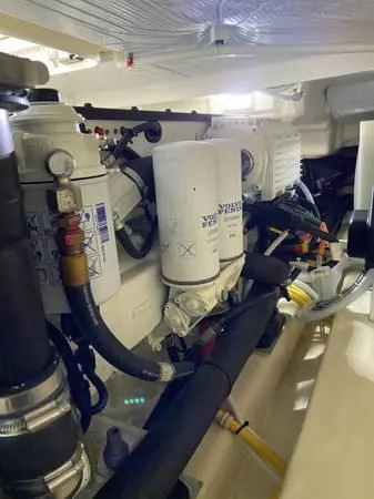 Slide: The Image of Engine compartment of 2019 Tiara Sport 39 boat, showcasing filters and hoses. - 16