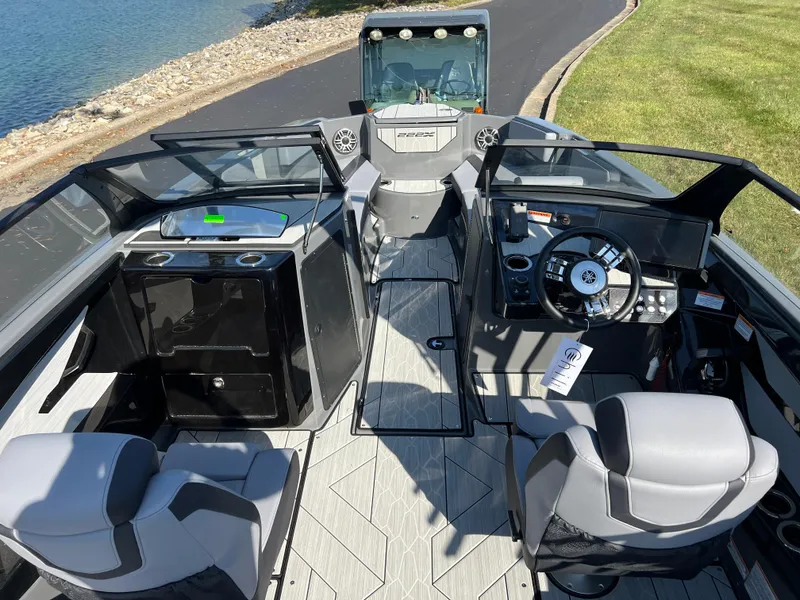 Slide: The Image of 2025 Yamaha Boats 222XD interior with modern dashboard and seating, docked by a lakeside. - 13