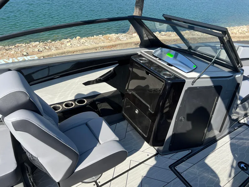 Slide: The Image of 2025 Yamaha Boats 222XD interior with sleek design and modern dashboard by the water. - 15