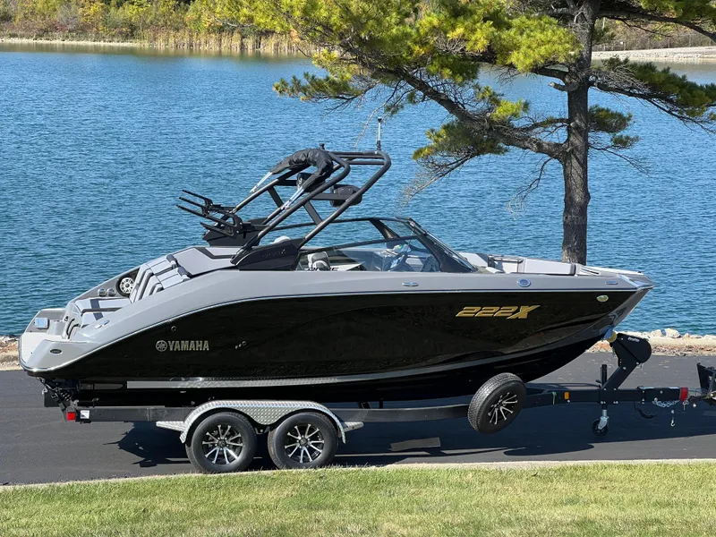 Slide: The Image of 2025 Yamaha Boats 222XD on trailer by a scenic lake. - 2