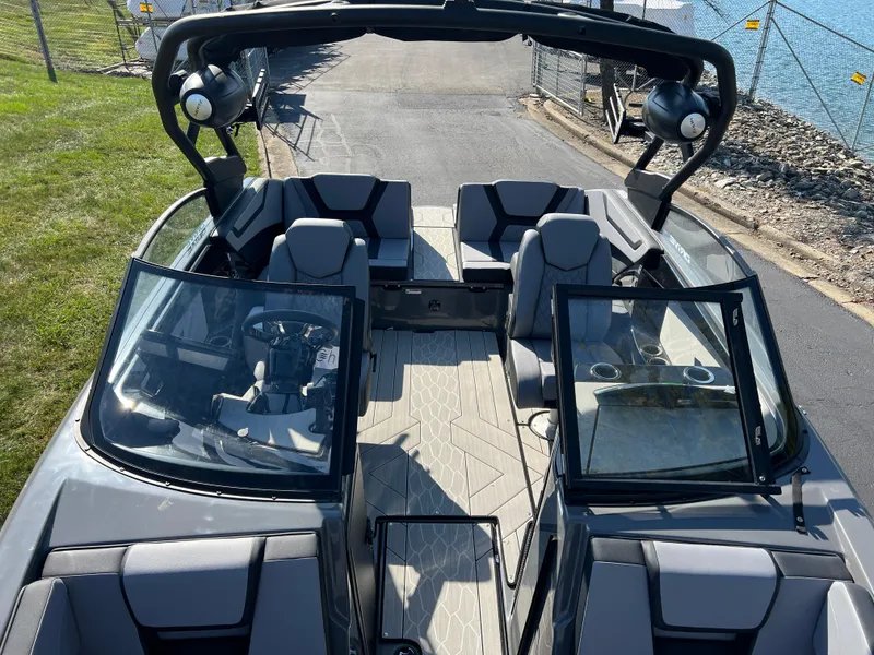 Slide: The Image of 2025 Yamaha Boats 222XD interior, open windshield, modern seating, docked by water. - 20