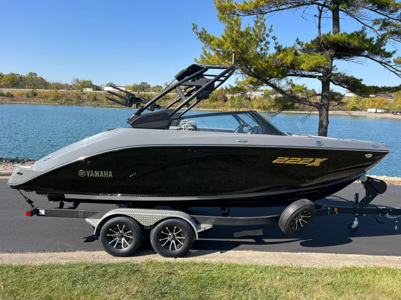 Slide: The Image of 2025 Yamaha Boats 222XD on trailer by a lake, side view. - 4